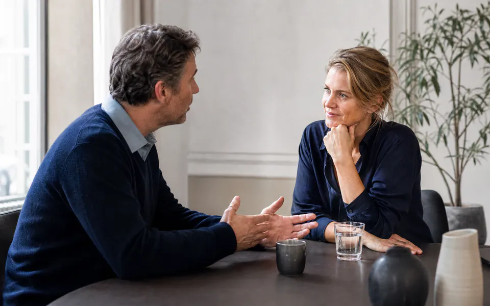 Twee mensen voeren aan tafel een rustig gesprek met oprechte aandacht